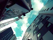 低角度镜头下，现代摩天大楼和起重机与充满活力的蓝天相映，突显了城市发展