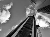 在戏剧性的天空下，现代摩天大楼和起重机构成了一幅引人注目的黑白景观