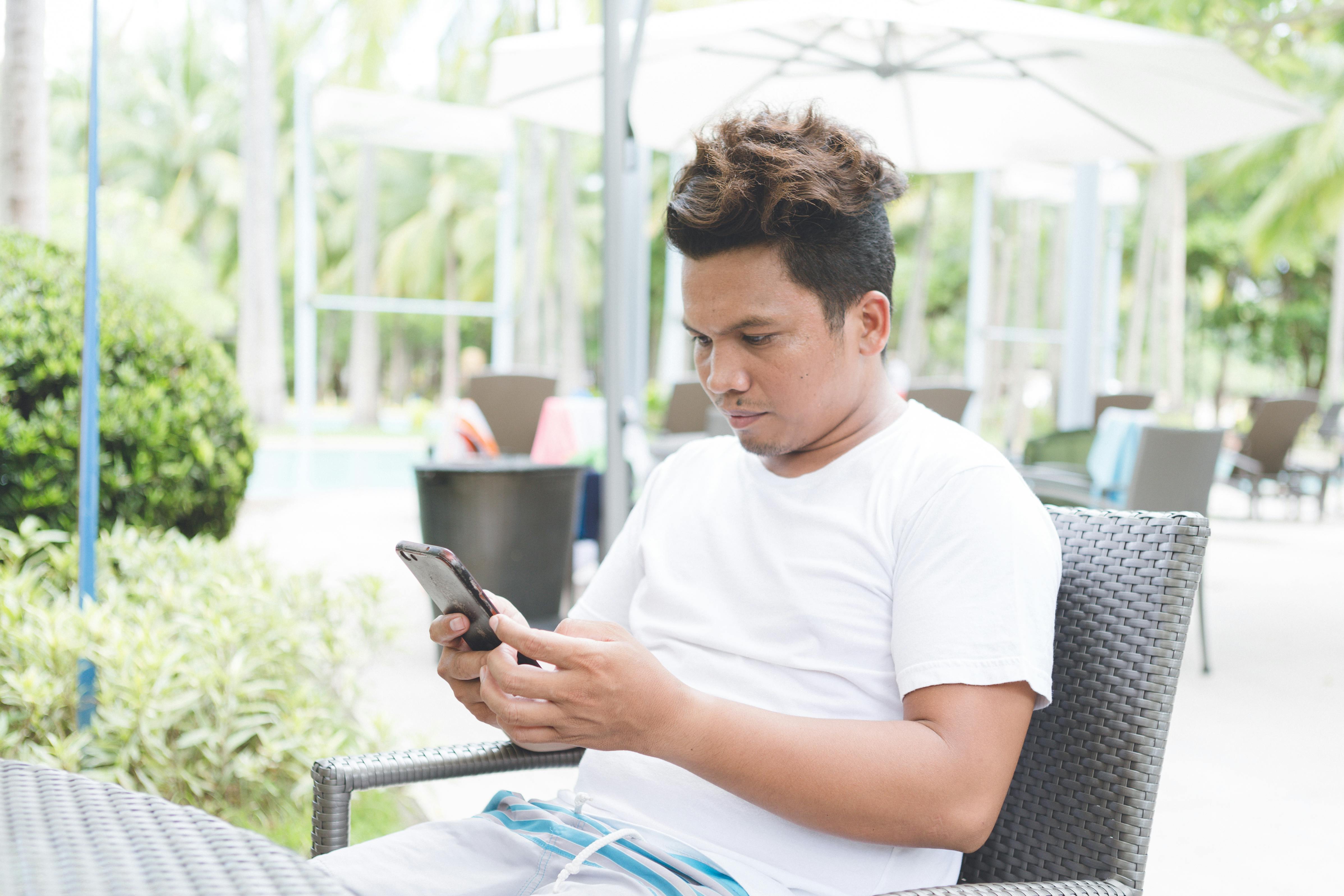 focused man browsing smartphone in outdoors cafe