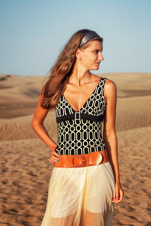 A Woman in Black and White Top Standing on the Sand