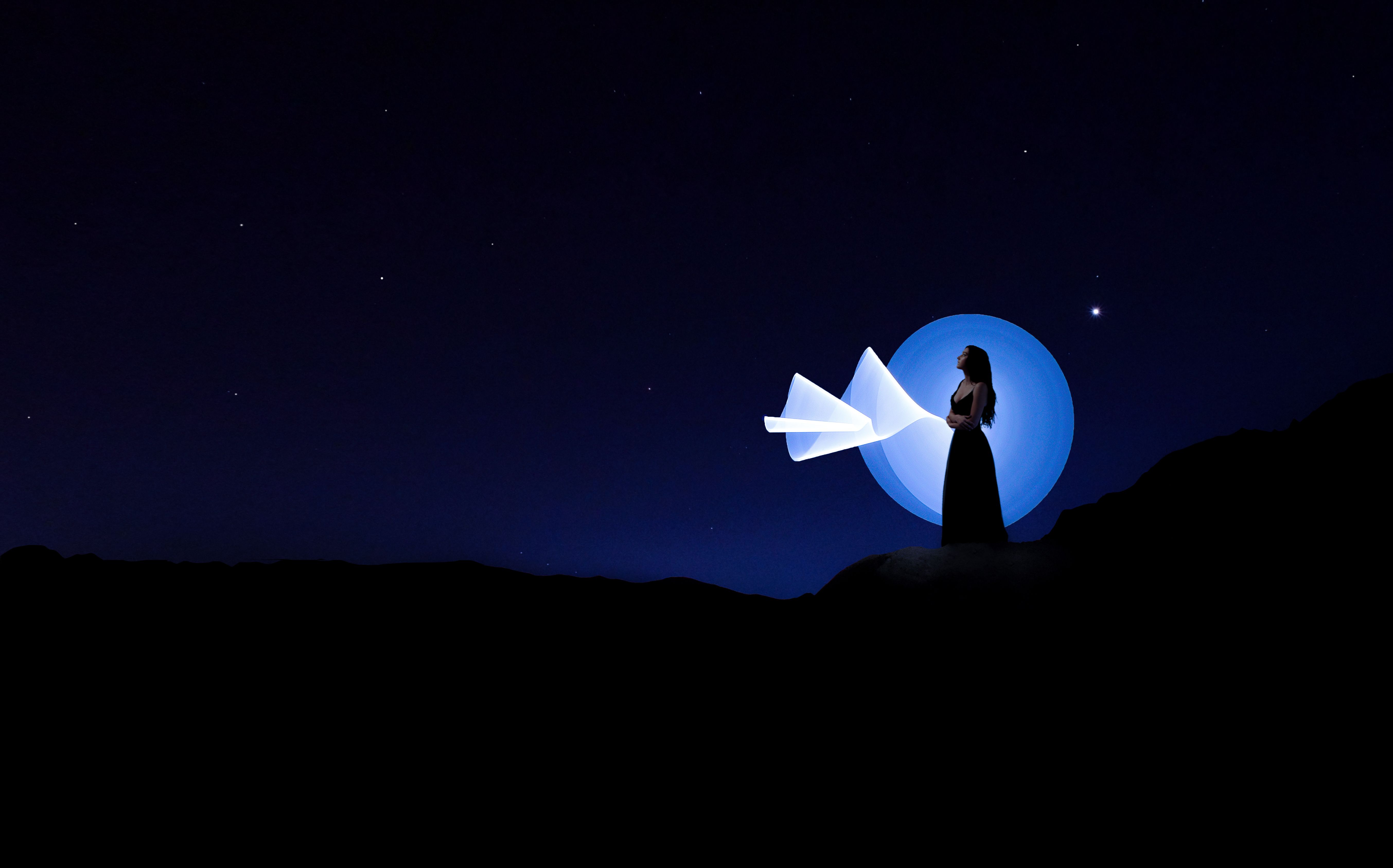 星光下，迷人的女性轮廓用创意的光线绘制出深蓝色的夜空