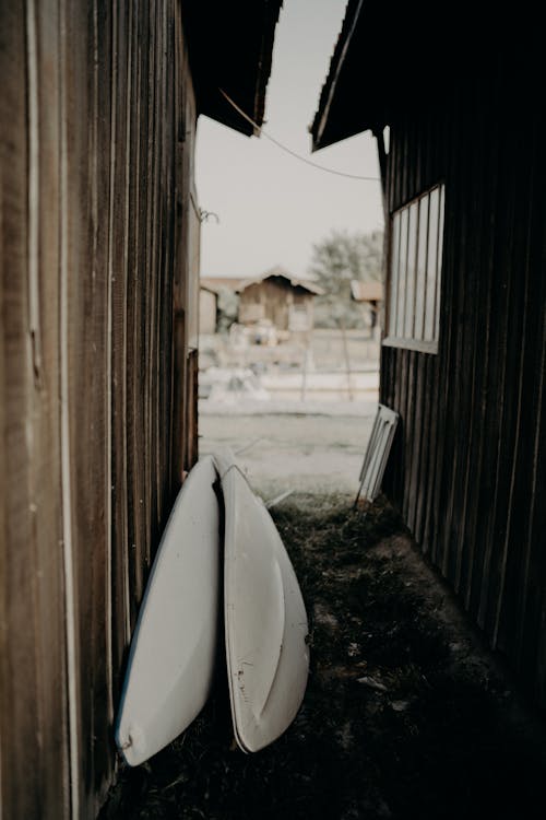 Surfboards on ground between weathered cottages