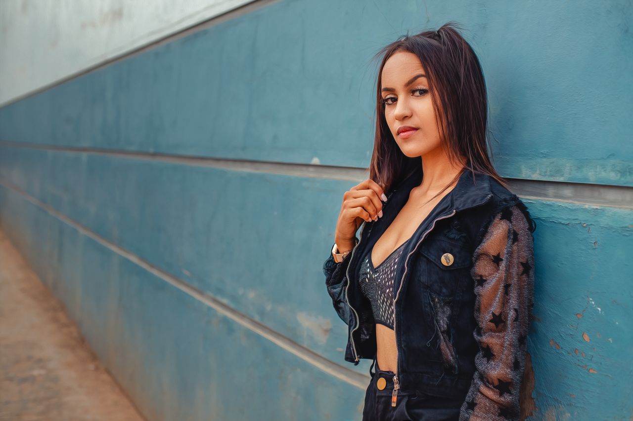 portrait of a stylish woman posing confidently against a textured blue