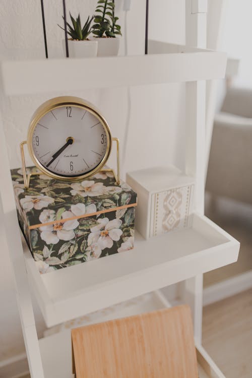 Alarm clock placed on shelf with decorative boxes in modern apartment