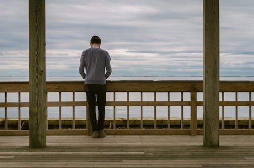 Free Man Standing at Front of Wooden Fence Stock Photo