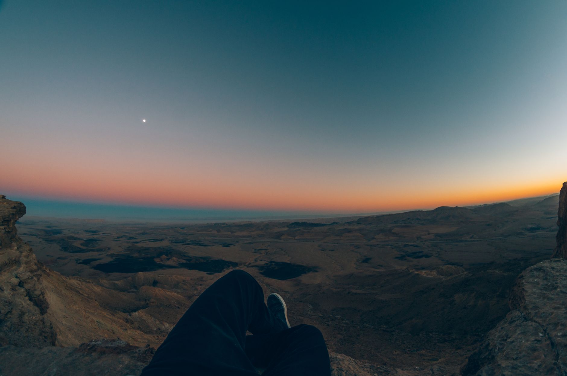 Experience the breathtaking view of a colorful sunset over the Mitzpe Ramon crater in Israel. โ photo by Nathan Engel / Pexels