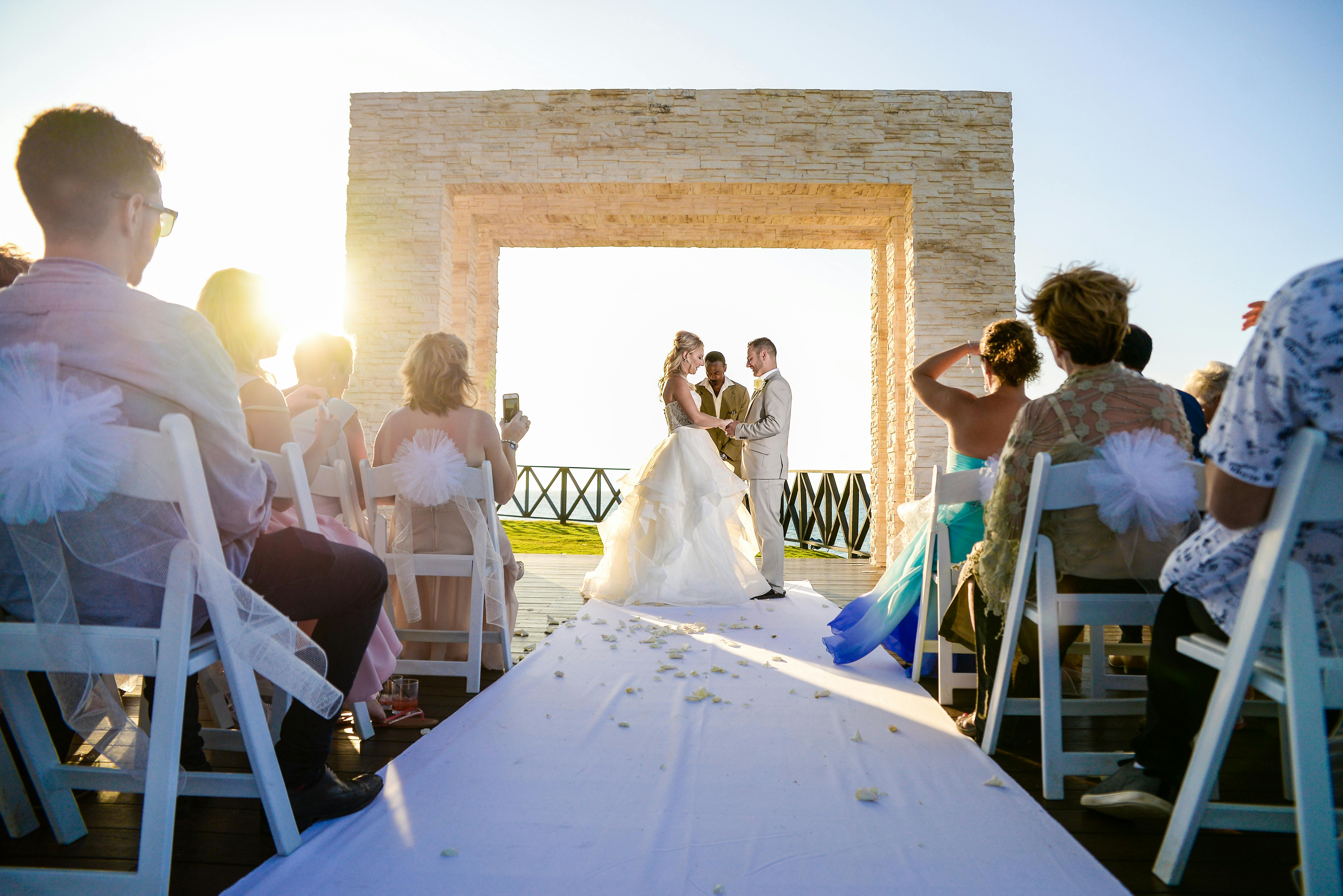 Wedding ceremony at a stunning outdoor beach venue, capturing love and togetherness at sunset.