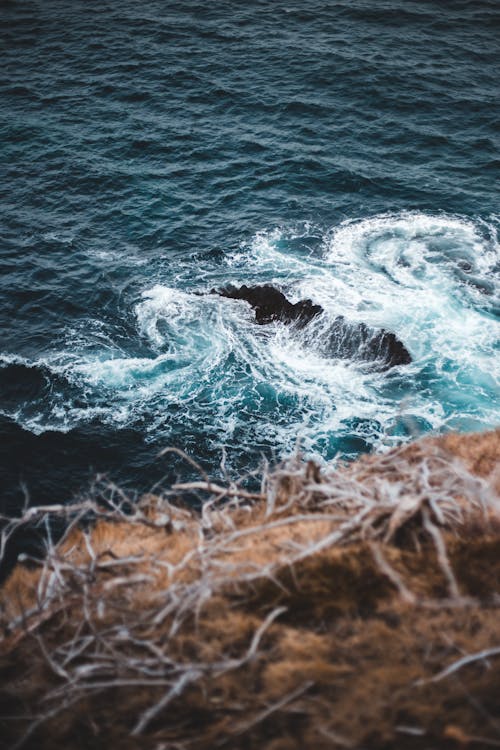 Swirling sea waves crashing on rocky cliffs