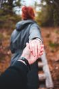 Unrecognizable man following girlfriend in forest