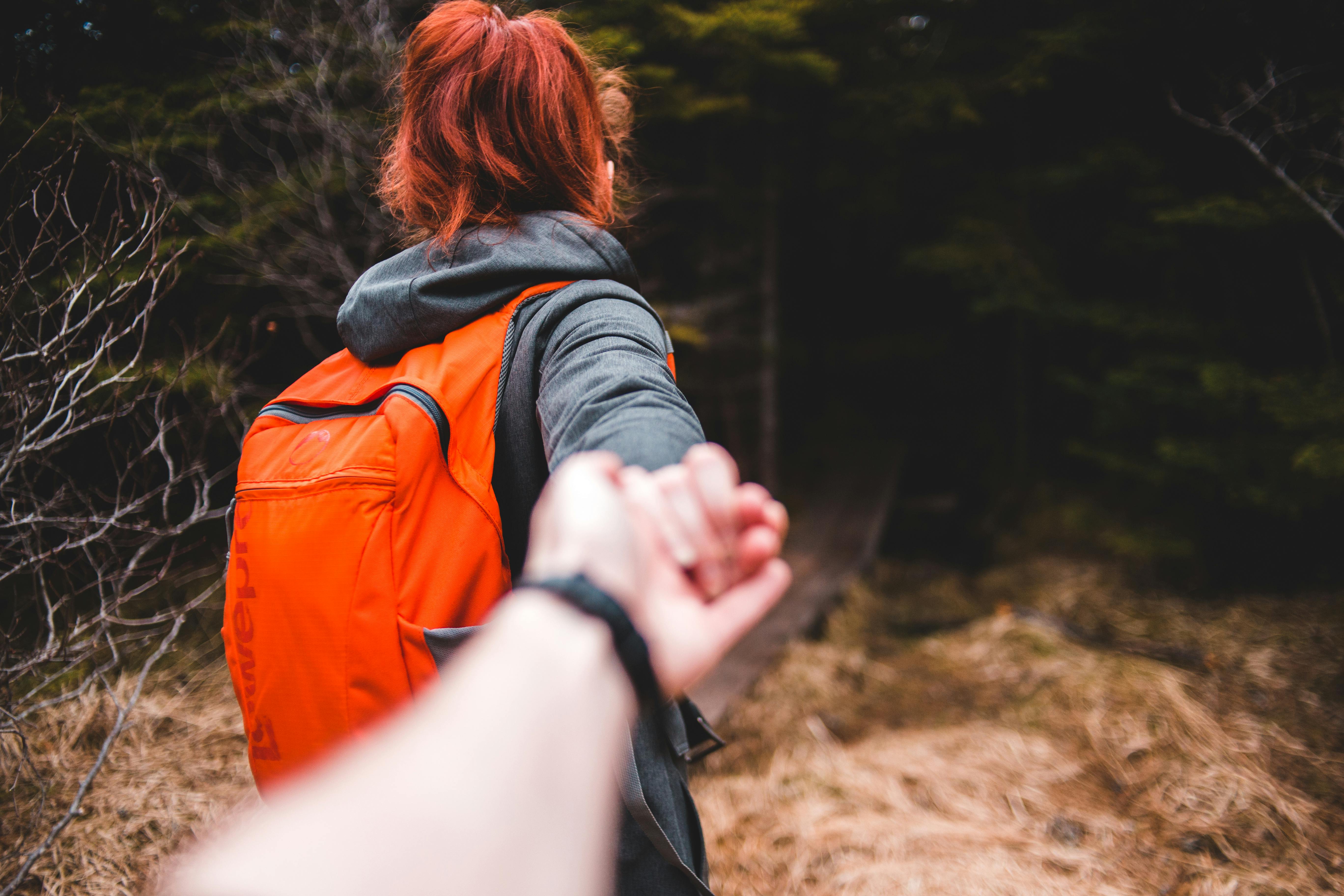 faceless traveler following girlfriend in national park