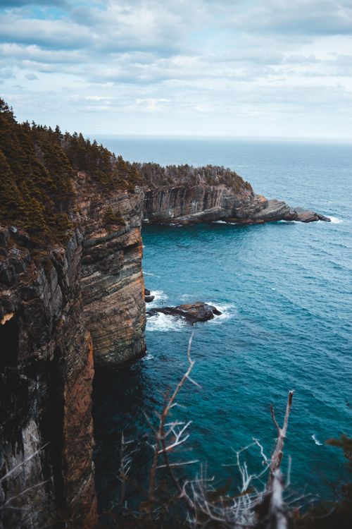 Free Majestic cliffs and ocean waves captured in a serene, scenic vertical shot. Stock Photo