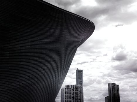 黑白图像中，现代摩天大楼和建筑矗立在戏剧性的多云天空下