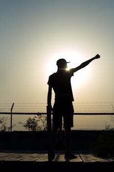 日落时分，一个人举起手臂的剪影象征着力量与个性