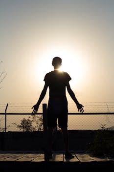 A silhouette of a person standing against a sunrise in Georgia, embodying freedom and individuality.