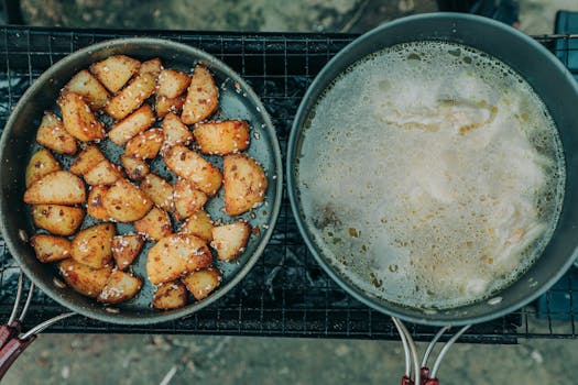 Delicious roasted potatoes and soup simmering outdoors, offering a rustic culinary experience.