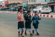 Group of teenagers walking and laughing on a street, showcasing youthful friendship and urban life.