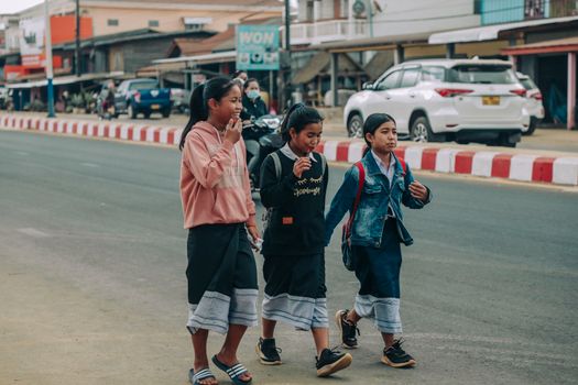 Group of teenagers walking and laughing on a street, showcasing youthful friendship and urban life.