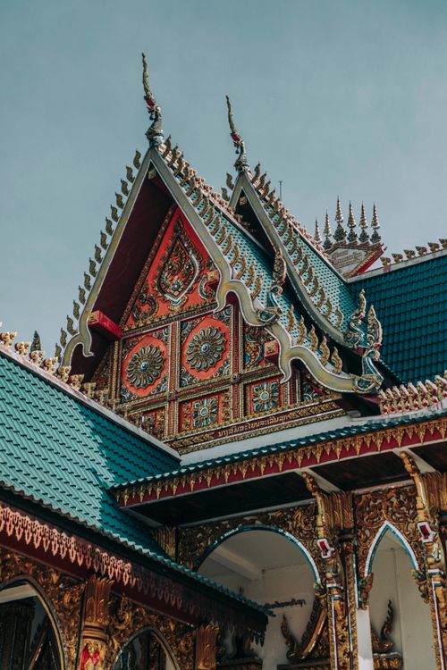 Free From below of ornamental walls and roof of aged Buddhist temple with spiky peaks on top Stock Photo