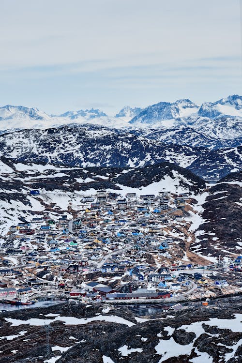 Village in snowy mountains under cloudy sky