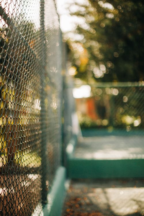 Free Close-up of an outdoor chain link fence with a beautiful bokeh effect in the background. Stock Photo