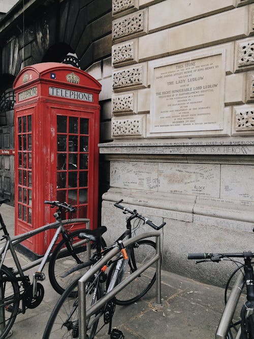 Red Telephone Booth Near Parked Bicycles