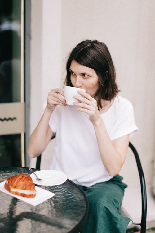 Free Photo of Woman Sitting While Drinking Coffee Stock Photo