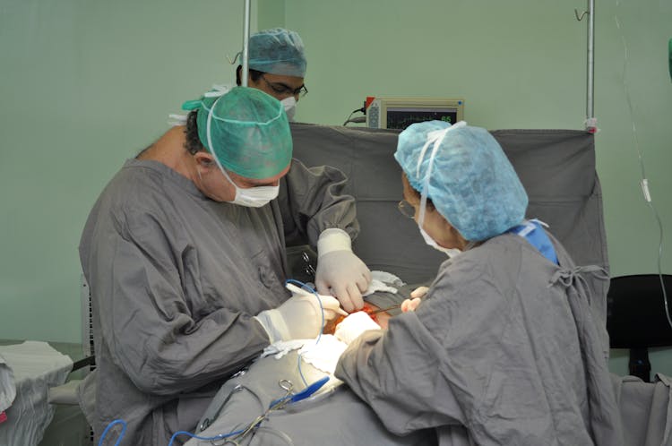 Doctors In Gray Scrub Suits Doing Surgery