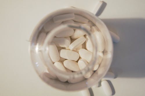 Free White Medication Pills in Clear Glass Jar Stock Photo