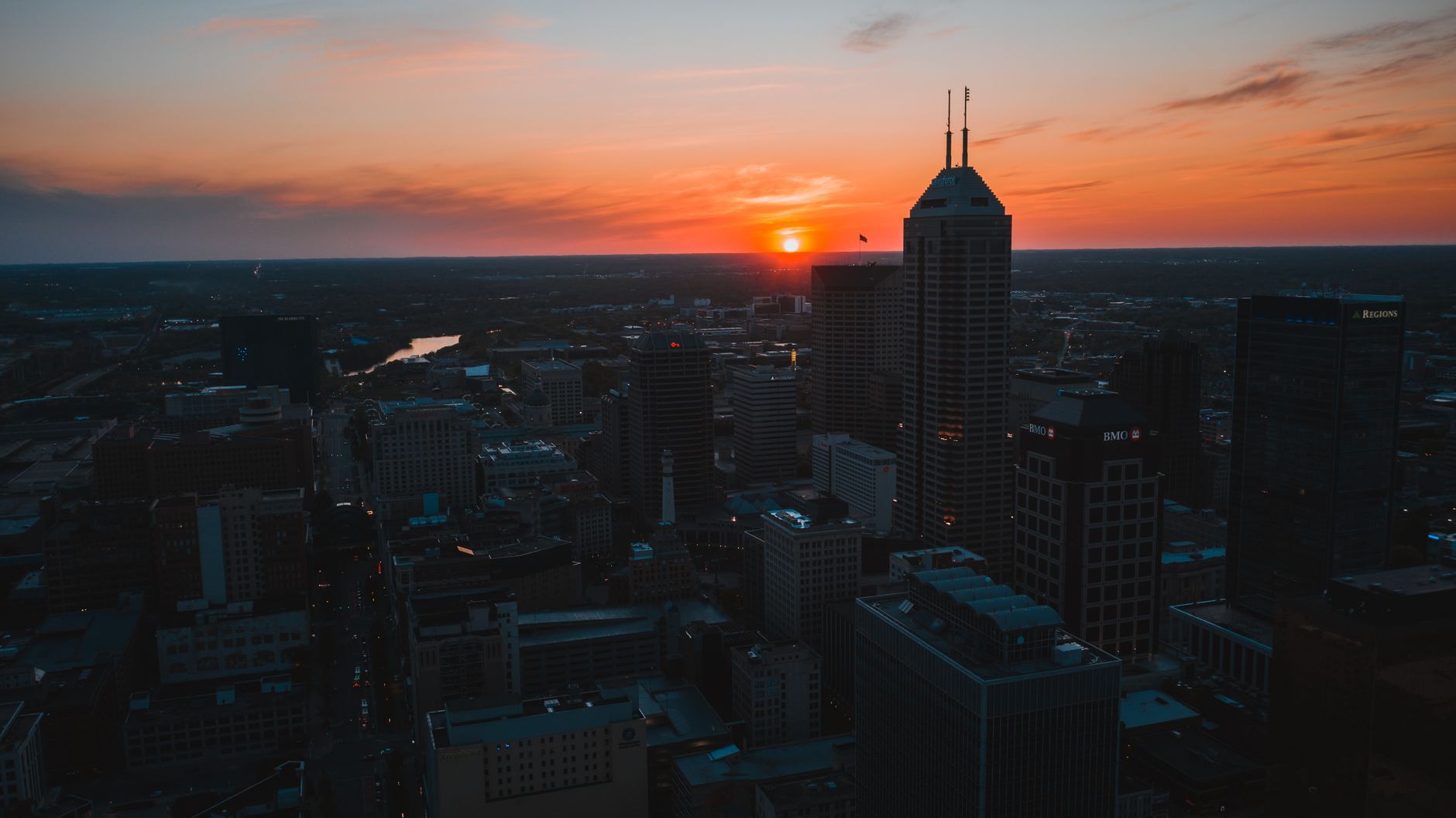 A stunning aerial view of Indianapolis downtown skyline during sunset, capturing the vibrant cityscape.