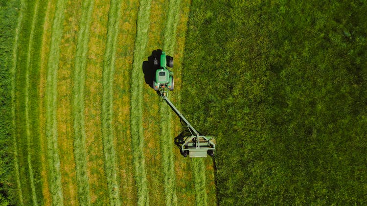 Top View Photo Of Tractor Landscape Rake On Grass Field