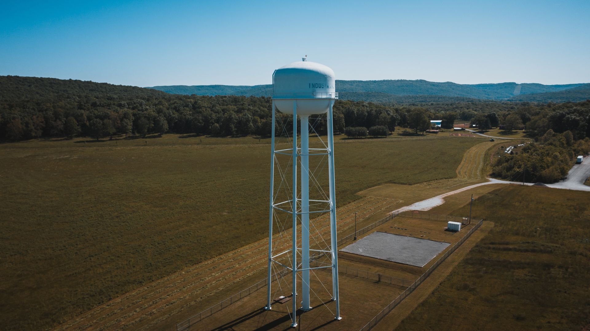 Elevated rural scene with a water tower and forested hills in Pelham, TN.