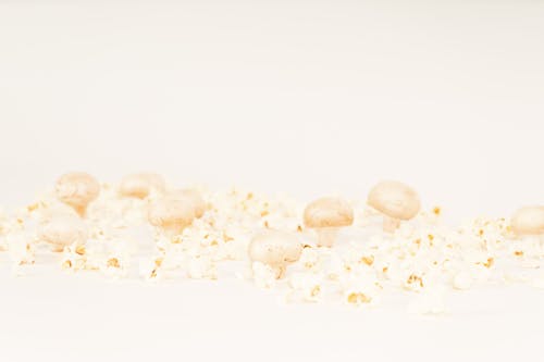 Mushrooms and Popcorns on a White Surface