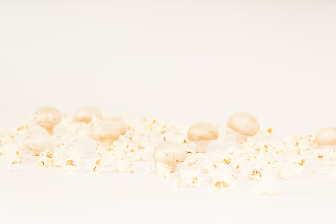 Mushrooms and Popcorns on a White Surface