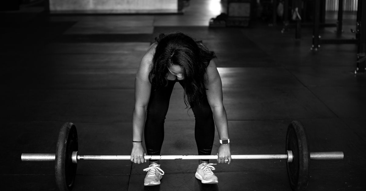 Black woman over 40 strength training with a barbell to build bone density