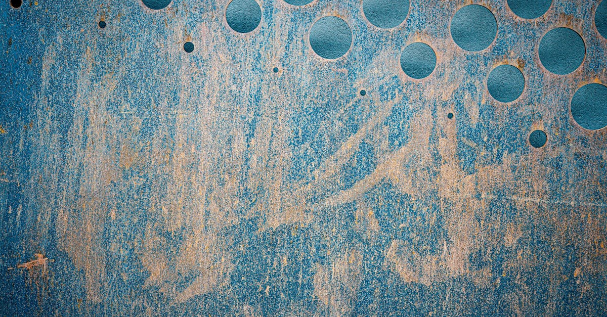 Rusty blue metal surface featuring circular cutouts, creating a unique geometric pattern.