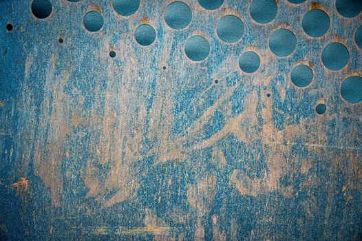 Textured backdrop of old metal wall with rusty surface and geometric circles in daylight