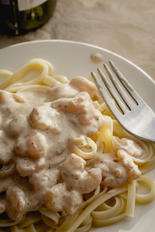 Free Close-up of creamy shrimp pasta with a rich white sauce on a plate. Stock Photo