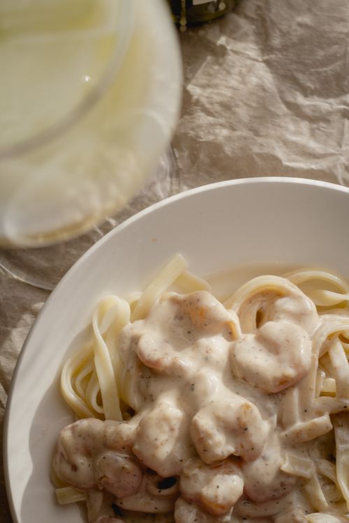 Free Close-up of creamy shrimp pasta served in a white bowl, perfect for Italian cuisine enthusiasts. Stock Photo