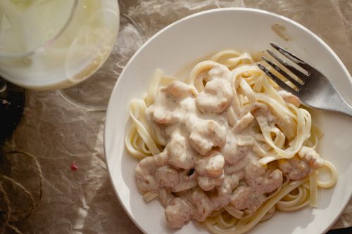 Free Delicious creamy shrimp Alfredo pasta served in a white bowl, perfect for Italian cuisine enthusiasts. Stock Photo