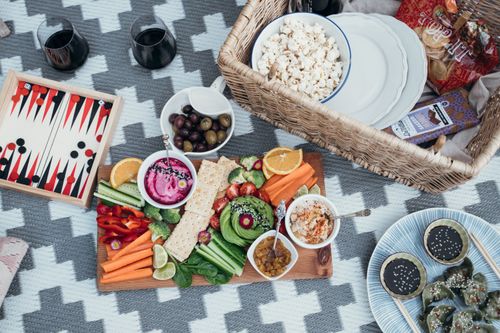 Free Colorful vegan picnic setup with variety of vegetables and snacks on a patterned blanket. Stock Photo