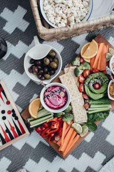Colorful vegetable platter with dips and crackers, perfect for healthy snacking outdoors.