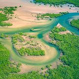 Aerial view of a river winding through a sandy valley, photo by Curioso Photography on Pexels