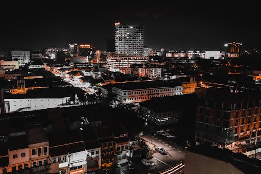 Explore a bustling city skyline beautifully illuminated under the night sky, showcasing vibrant city lights.