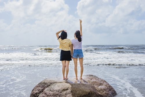 Women Standing on Top of Boulder