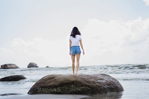 Woman Standing on Top of Boulder