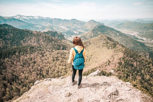 Woman overlooks Malá Fatra mountain range in Slovakia. Captivating scenic view from peak.