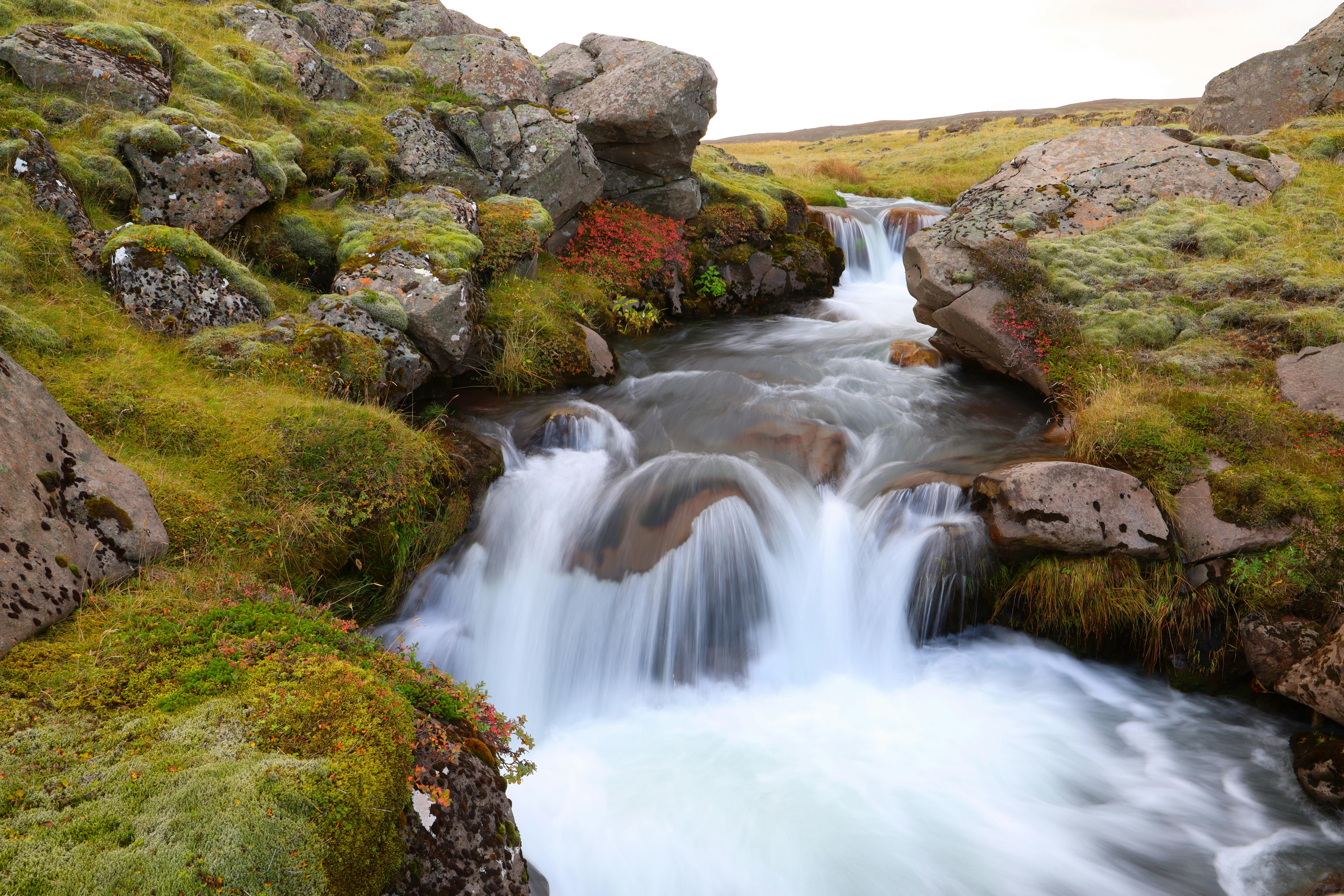 冰岛美丽的瀑布流经岩石景观，展现了大自然的宁静