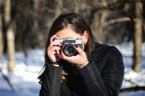 Woman in Black Jacket Holding Black and Silver Camera