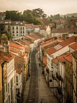 From above perspective scenery of old town street with small residential buildings aside narrow empty roadway during tranquil summer day