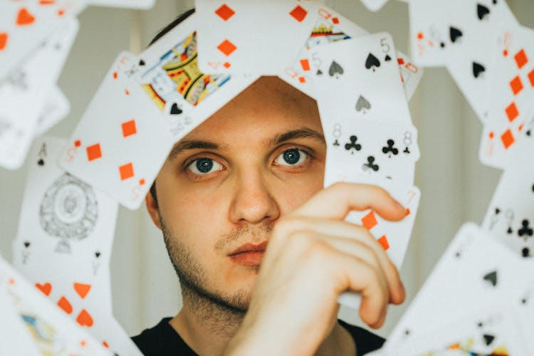 Playing Cards Around A Man's Face